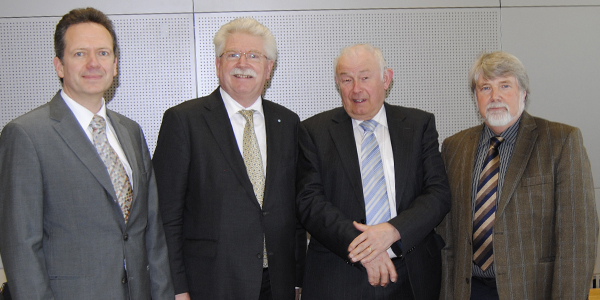 Perry Reisewitz, Martin Zeil, Günther Beckstein und Michael Schröder stehen nebeneinander im Hörsaal der Akademie für Politische Bildung und lächeln in die Kamera