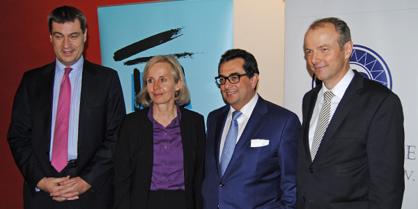 Markus Söder, Ursula Münch, Stavros Kostantinidis und Karl Schnitzler stehen nebeneinander und lächeln in die Kamera