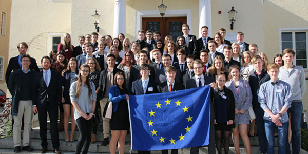 Die Teilnehmer der trinationalen Schülerakademie und ihre Organisatoren Daniel Göler, Andreas Kalina und Robert Lohmann posieren für ein Gruppenfoto. Die vordersten Schüler und Schülerinnen halten eine Europaflagge hoch