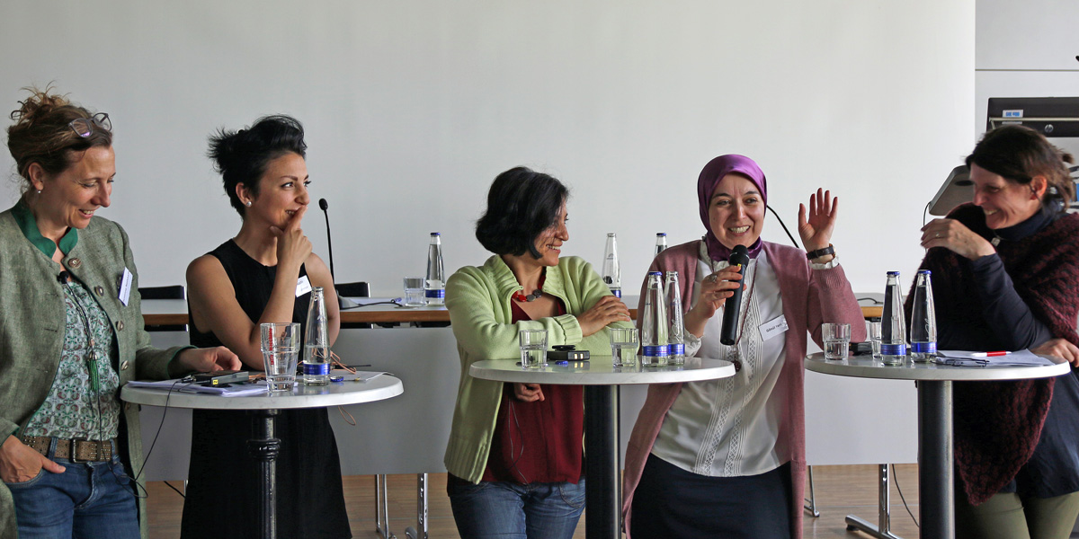 Susanne Nothhafft, Nuschin Rawanmehr, Sükran Aslan, Gönül Yerli und Annette Eberle stehen an drei Stehtischen und führen ein Gespräch