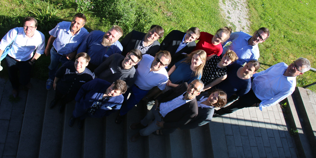 Alle Referentinnen und Referenten der Tagung "Verfolgung, Diskriminierung, Emanzipation" stehen auf einer Treppe im Garten der Akademie für Politische Bildung und schauen nach oben