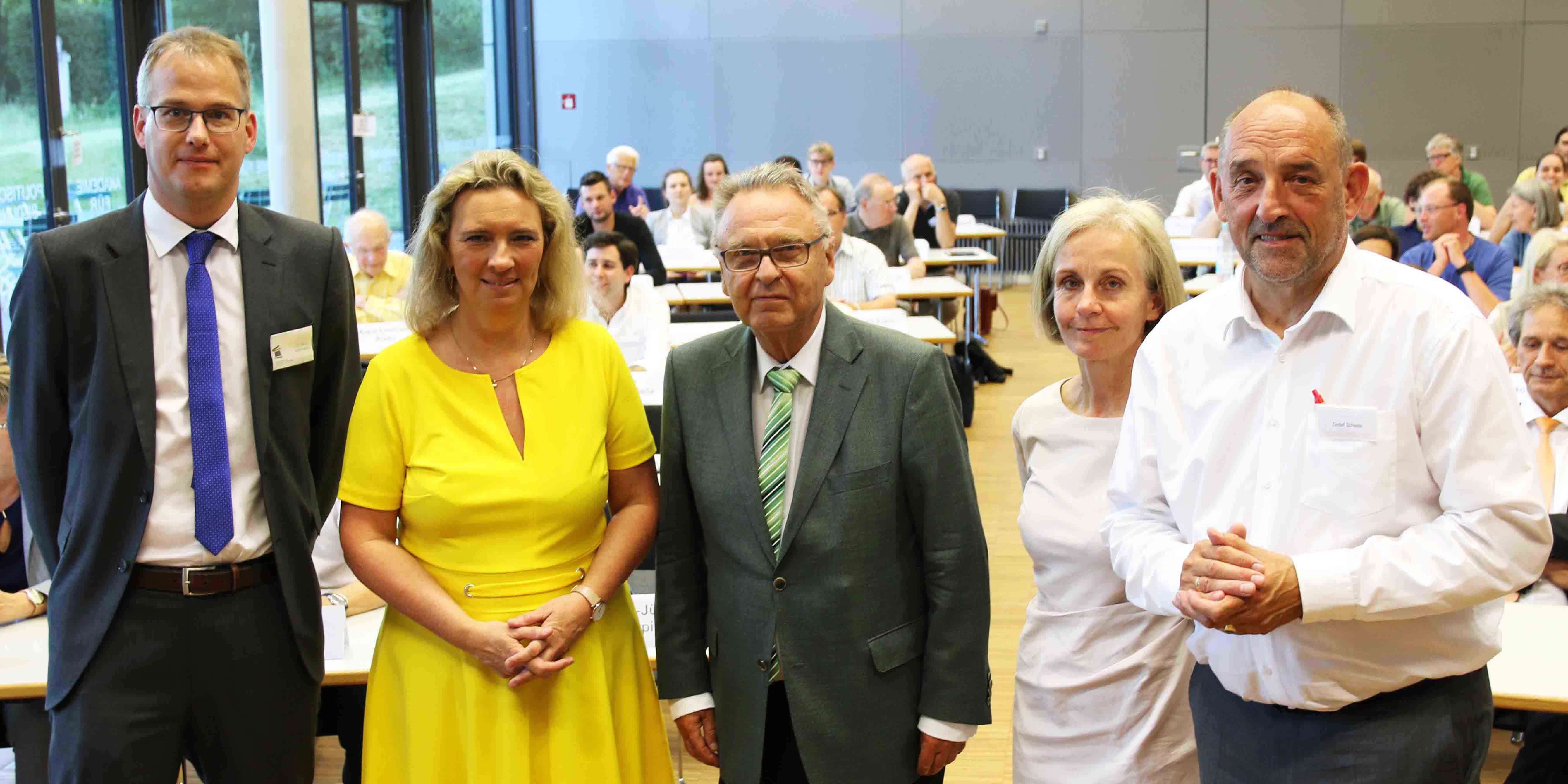 Gero Kellermann, Kerstin Schreyer, Hans-Jürgen Papier, Ursula Münch und Detlef Scheele stehen nebeneinander im Hörsaal der Akademie für Politische Bildung Tutzing und lächeln in die Kamera. Im Hintergrund sitzen Personen an Tischen 