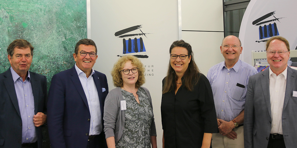 Henning Klodt, Franz Josef Pschierer, Christine Bergmann, Saskia Hieber, Wolfgang Quaisser und Jochen Kubosch stehen nebeneinander in der Akademie für Politische Bildung und lächeln in die Kamera. Im Hintergrund ist das Logo der Akademie