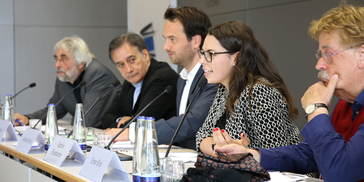 Elmar Brok, Sophie Griesbacher, Andreas Kalina, Ralf Bingel und Edgar Grande sitzen an Tischen auf dem Pult der Akademie für Politische Bildung Tutzing.