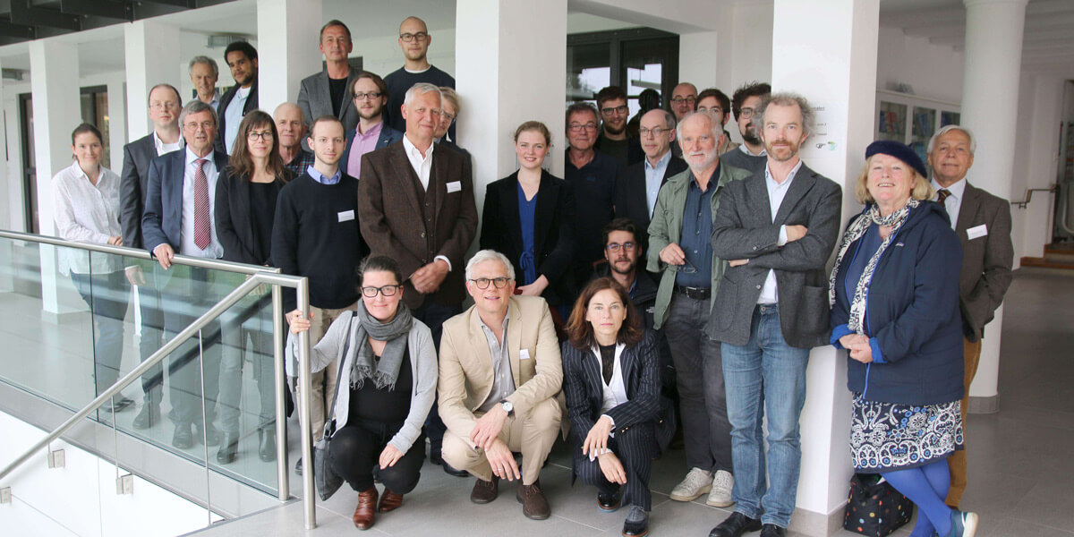 Mehrere Personen stehen im Flur der Akademie für Politische Bildung Tutzing und lächeln in die Kamera