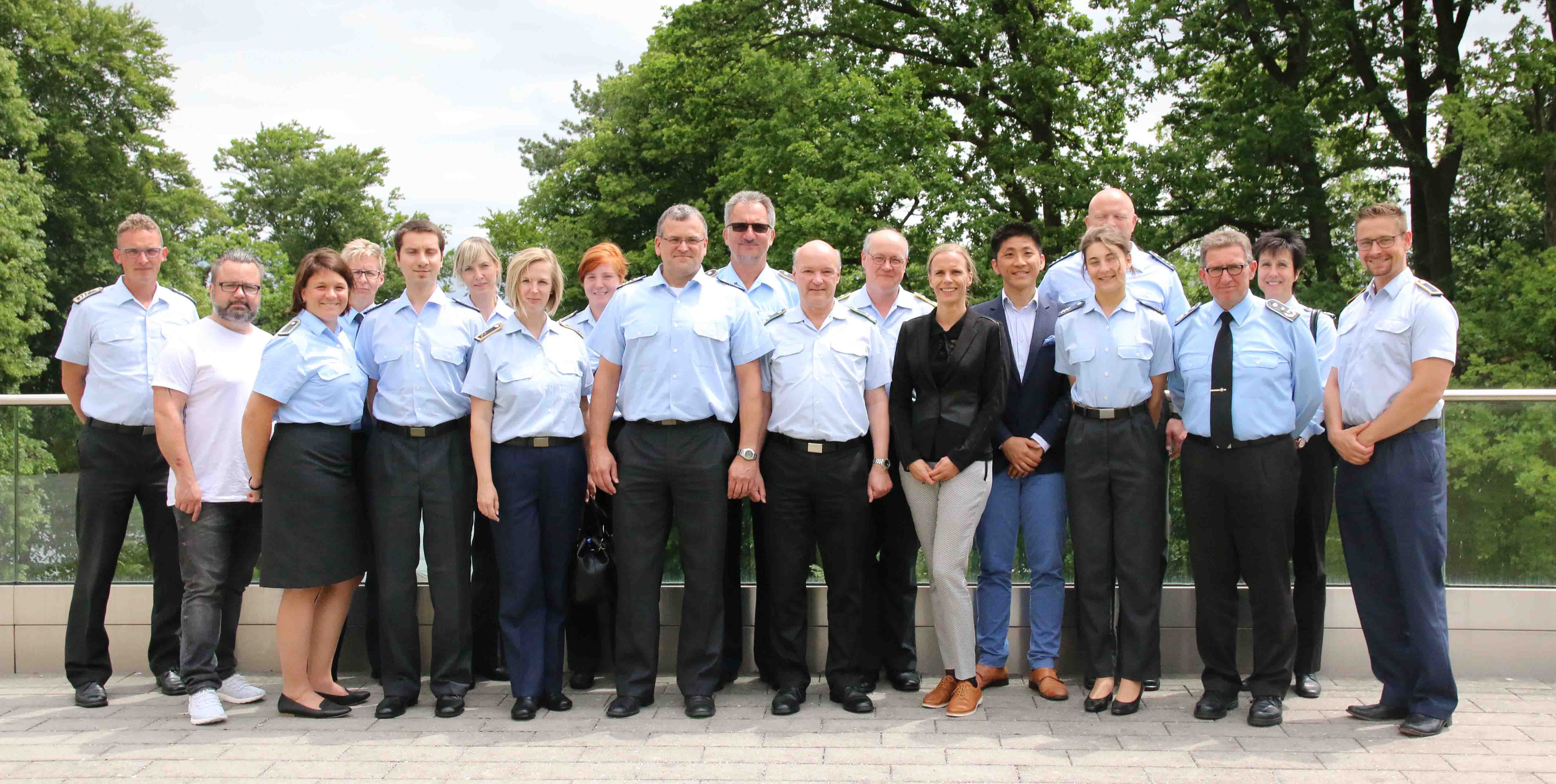 Sanitäterinnen und Sanitäter der Bundeswehr stehen gemeinsam mit Anja Opitz und Chenchao Liu im Garten der Akademie für Politische Bildung Tutzing