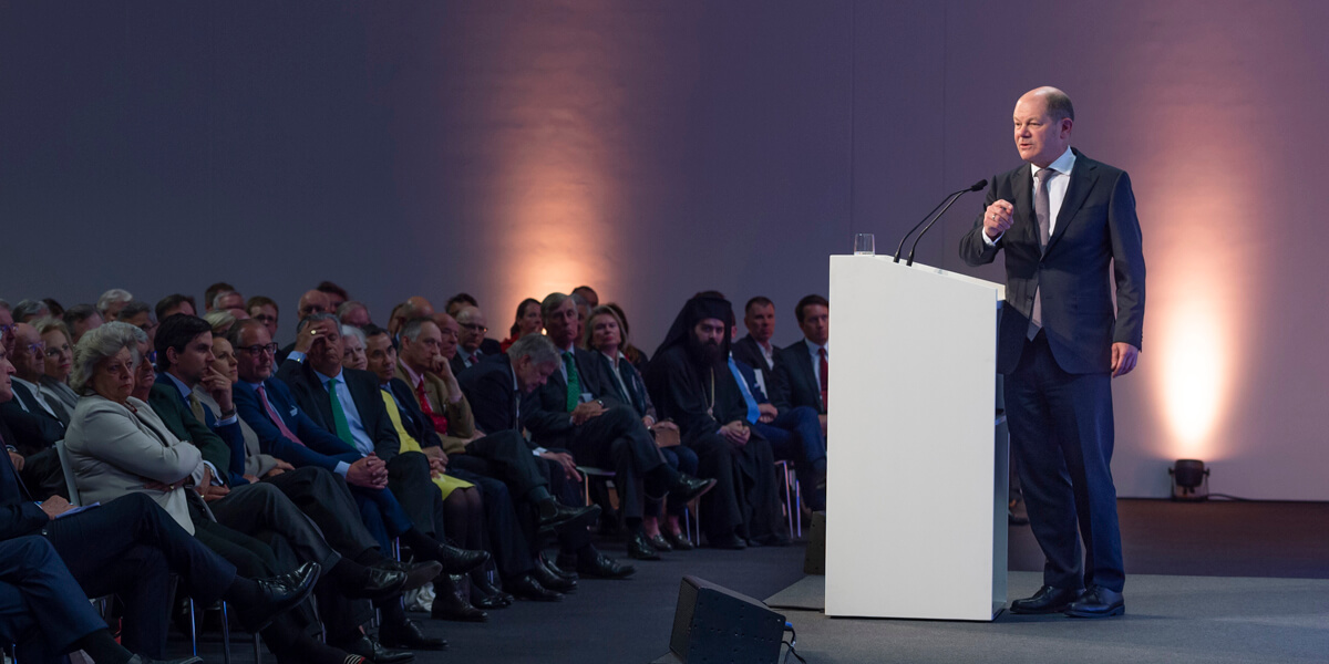 Olaf Scholz steht an einem Rednerpult und redet. Vor ihm sitzt ein großes Publikum. 