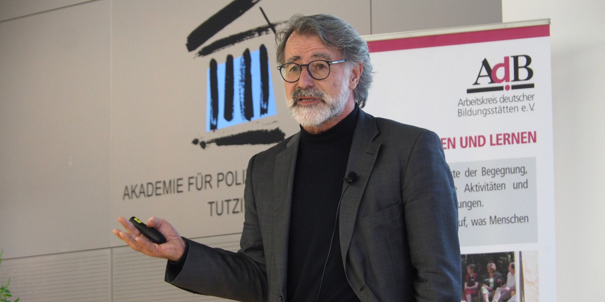 Wolfgang Merkel steht auf dem Podium des Hörsaals der Akademie für Politische Bildung Tutzing und hält einen Vortrag