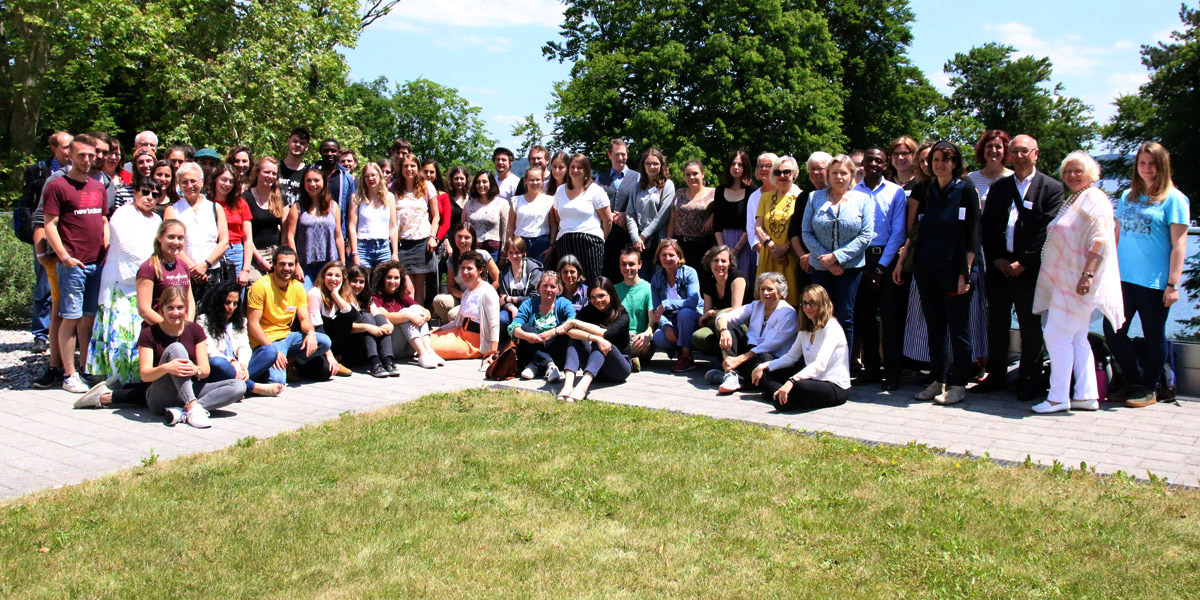 Die Teilnehmenden der Tagung "Gedenken, Aufarbeitung, Versöhnung" stehen im Garten der Akademie für Politische Bildung Tutzing und lächeln in die Kamera