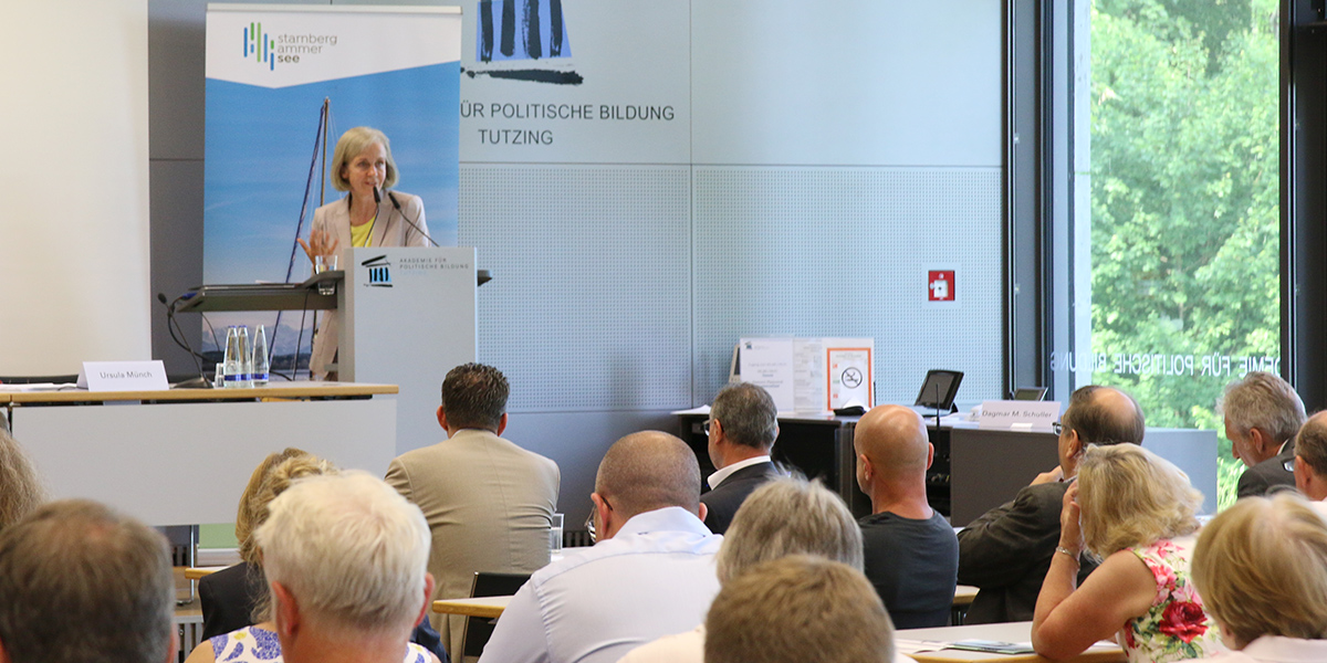 Ursula Münch steht auf dem Podium des Hörsaals der Akademie für Politische Bildung und redet. Vor ihr sitzt Publikum und hört ihr zu