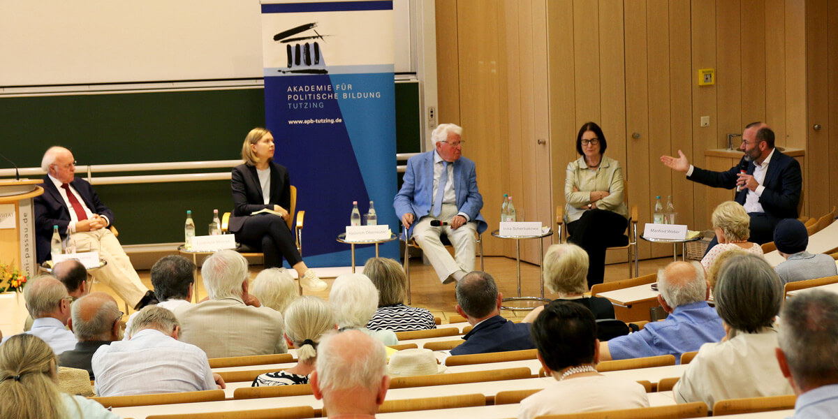 Jackson Janes, Ljudmyla Melnyk, Heinrich Oberreuter, Irina Scherbakowa und Manfred Weber sitzen im Halbkreis in einem Hörsaal vor Publikum. Im Hintergrund ist eine Tafel und ein Aufsteller mit dem Logo der Akademie zu sehen. Manfred Weber spricht. Die anderen hören zu.