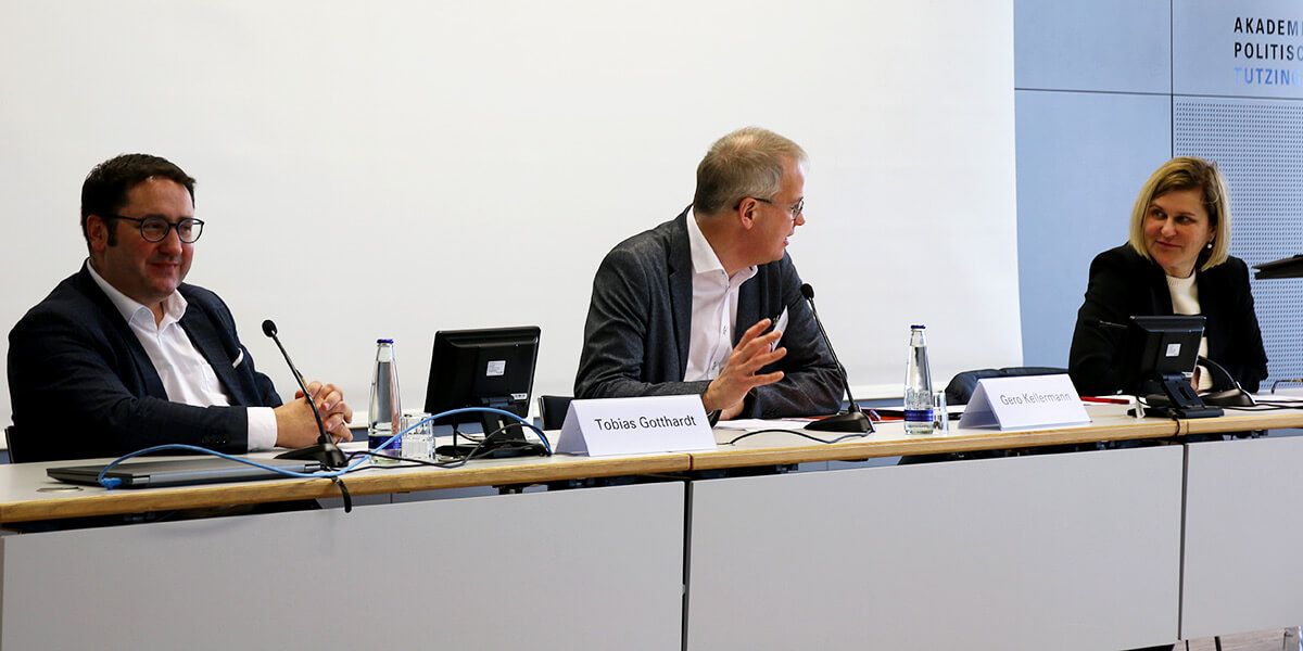 Tobias Gotthardt, Gero Kellermann und Simone Strohmayr sitzen auf dem Podium der Akademie für Politische Bildung. Gero Kellermann spricht, die anderen beiden wenden sich ihm zu.