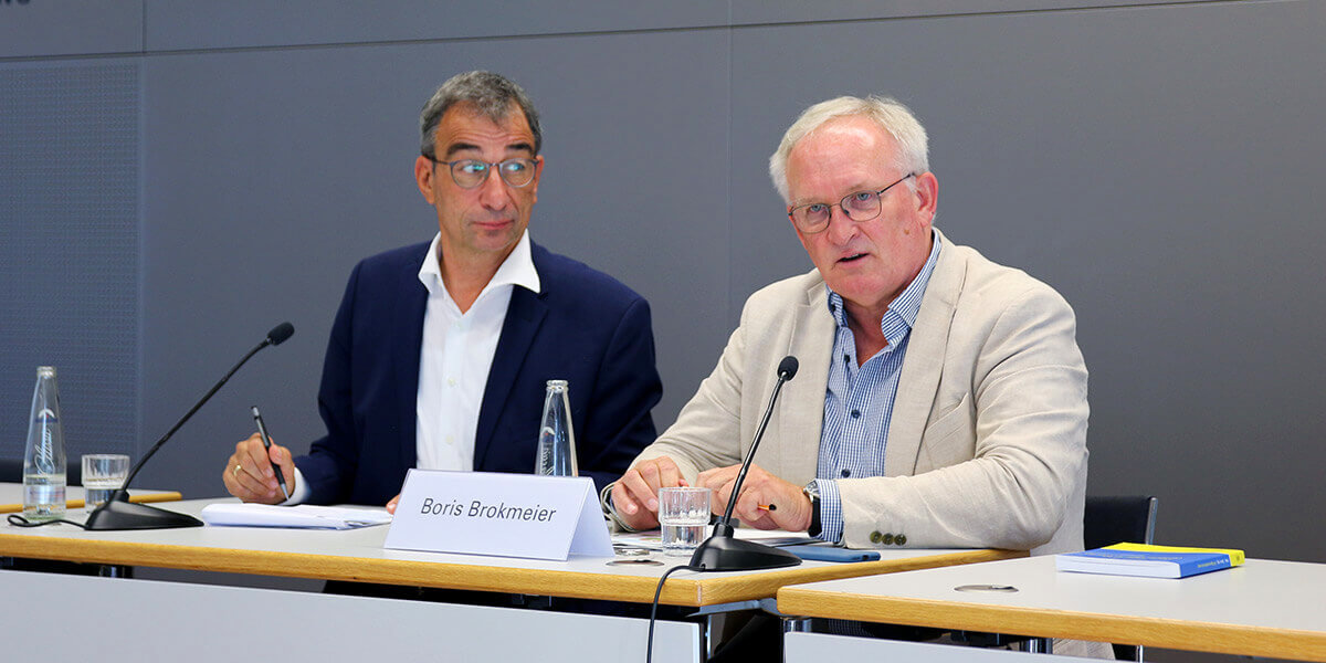 Boris Brockmeier sitzt auf dem Podium der Akademie für Politische Bildung und spricht in ein Mikrofon. Links von ihm sitzt Stefan Rappenglück und sieht ihn an.