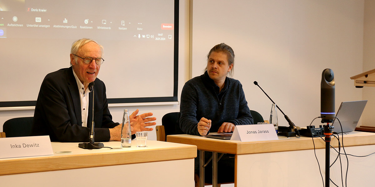 Alois Heißenhuberund Jonas Jarass sitzen auf dem Podium in der Akademie für Politische Bildung und reden.