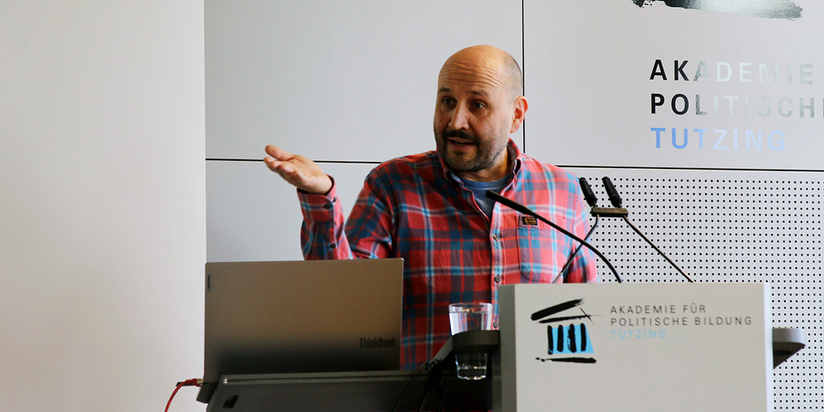 Gregor Walter von Kidslab steht in der Akademie für Politische Bildung am Rednerpult und spricht.