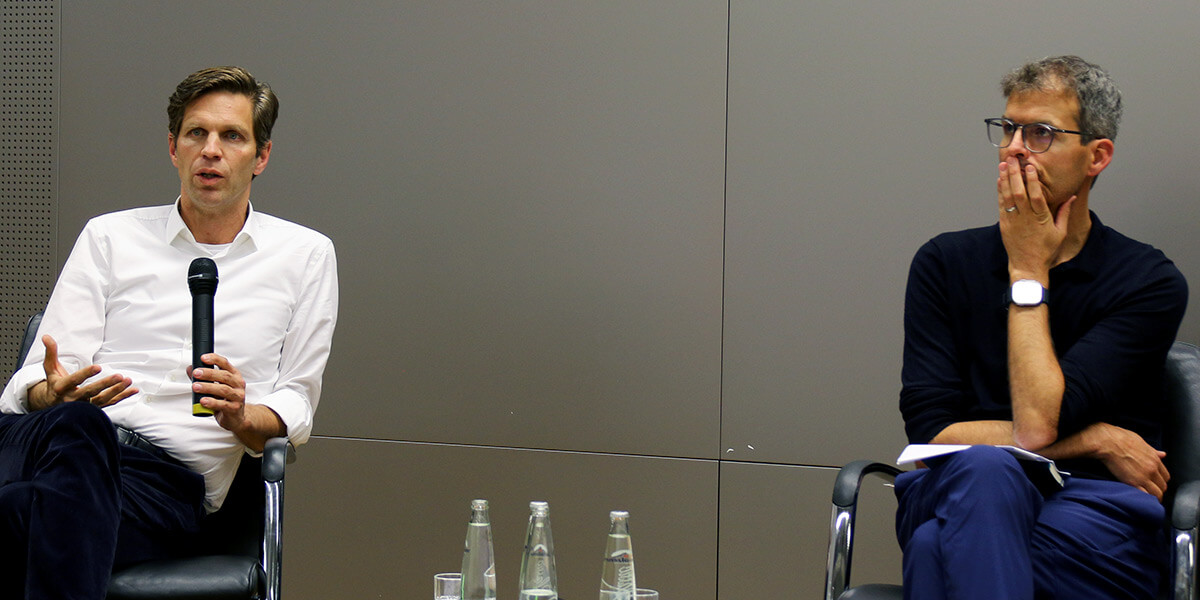 Johannes Lindner und Berthold Rittberger diskutieren miteinander auf dem Podium.
