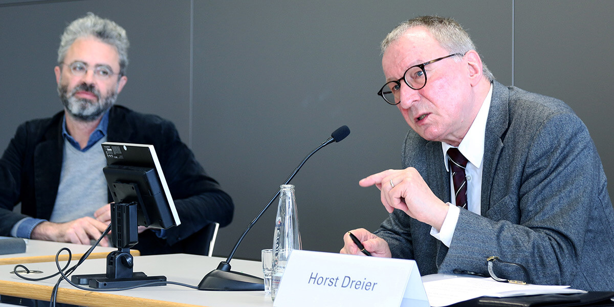 Horst Dreier sitzt auf dem Podium der Akademie für Politische Bildung und spricht in ein Mikrofon. Links neben ihm sitzt Maximilian Steinbeis und wendet sich ihm zu.