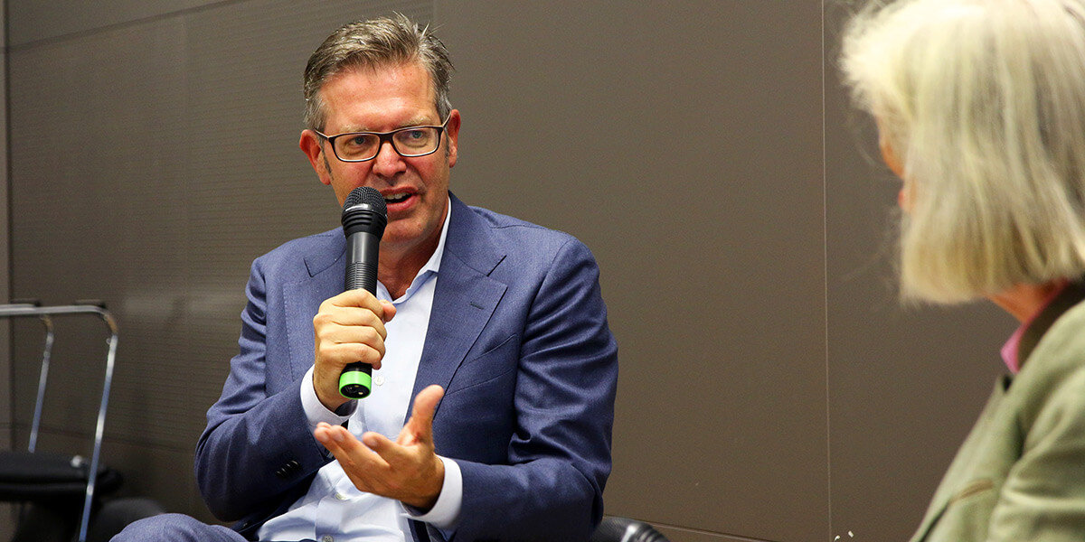 Prof. Dr. Steffen Weber beantwortet eine Frage und spricht am Mikrofon. Im rechten Eck sieht man den Rücken von Prof. Dr. Ursula Münch.