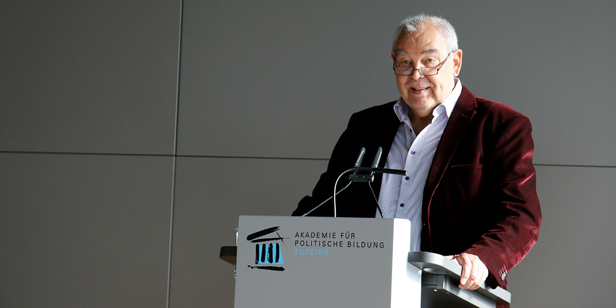 Thomas Gutknecht steht am Pult der Akademie für Politische Bildung und spricht in einem Mikrofon