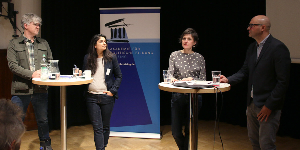 Ella Schindler steht im Vortragsraum der Seidlvilla an einem Stehtisch und spricht. Links stehen Lars Rademacher und Kinza Khan. Rechts steht Mark Dang-Anh. Sie wenden sich alle Ella Schindler zu.