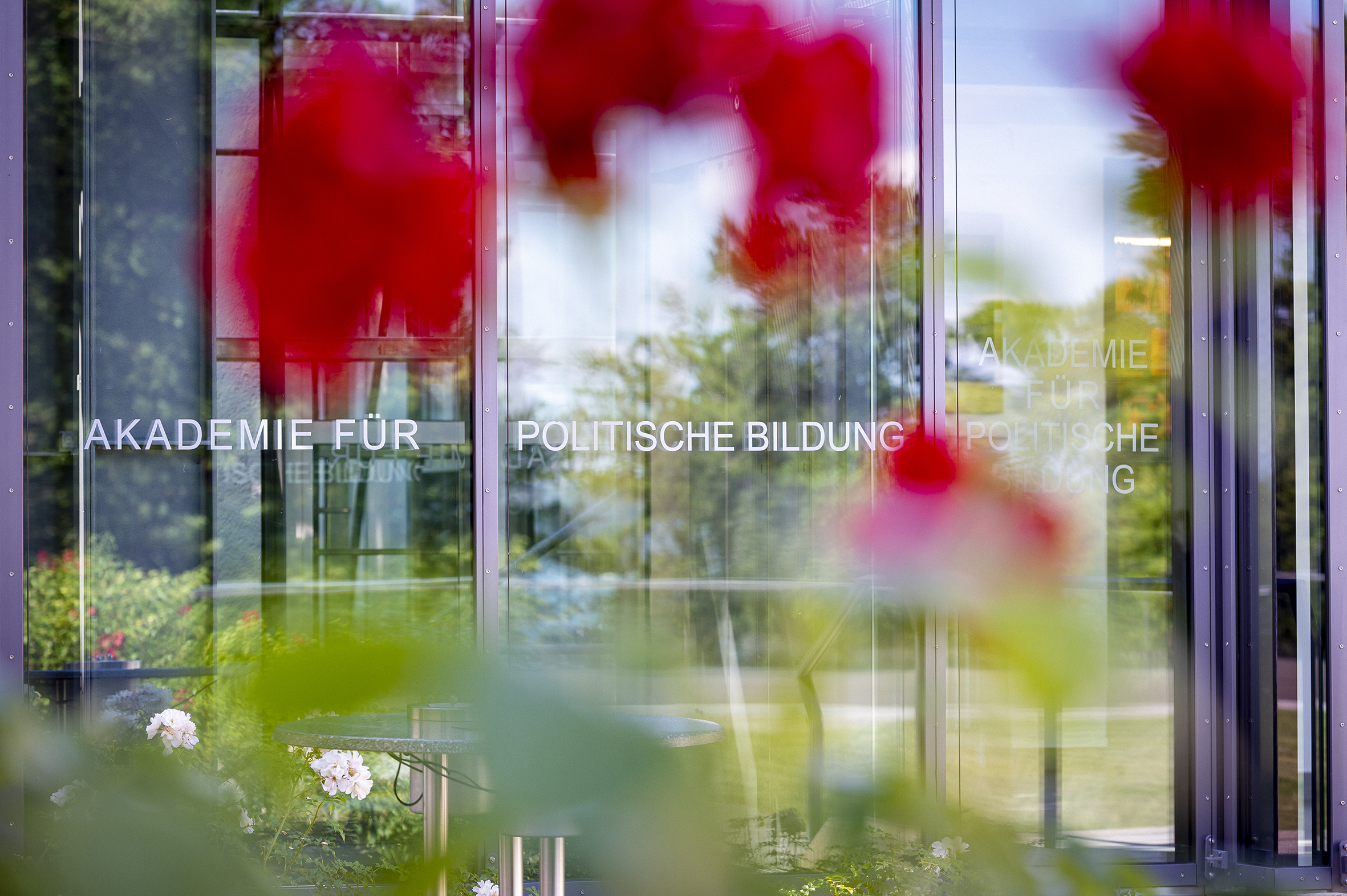 Durch eine Scheibe ist der Garten der Akademie für Politische Bildung zu sehen