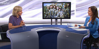 Links sitzt Ursula Münch an einem halb runden Tisch im Studio von alpha-demokratie, rechts Mirjam Kottmann. Im Hintergrund ist ein Bildschirm zu sehen