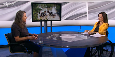 Links sitzt Saskia Hieber an einem großen runden Tisch im Studio von alpha-demokratie, rechts Mirjam Kottmann. Im Hintergrund ist ein Bildschirm zu sehen.
