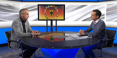 Gero Kellermann sitzt links im Studio von alpha-demokratie, ihm gegenüber am runden Tisch Tilman Seiler. Im Hintergrund ist ein Bildschirm mit dem Wappen des Bundes und der 16 Länder zu sehen.