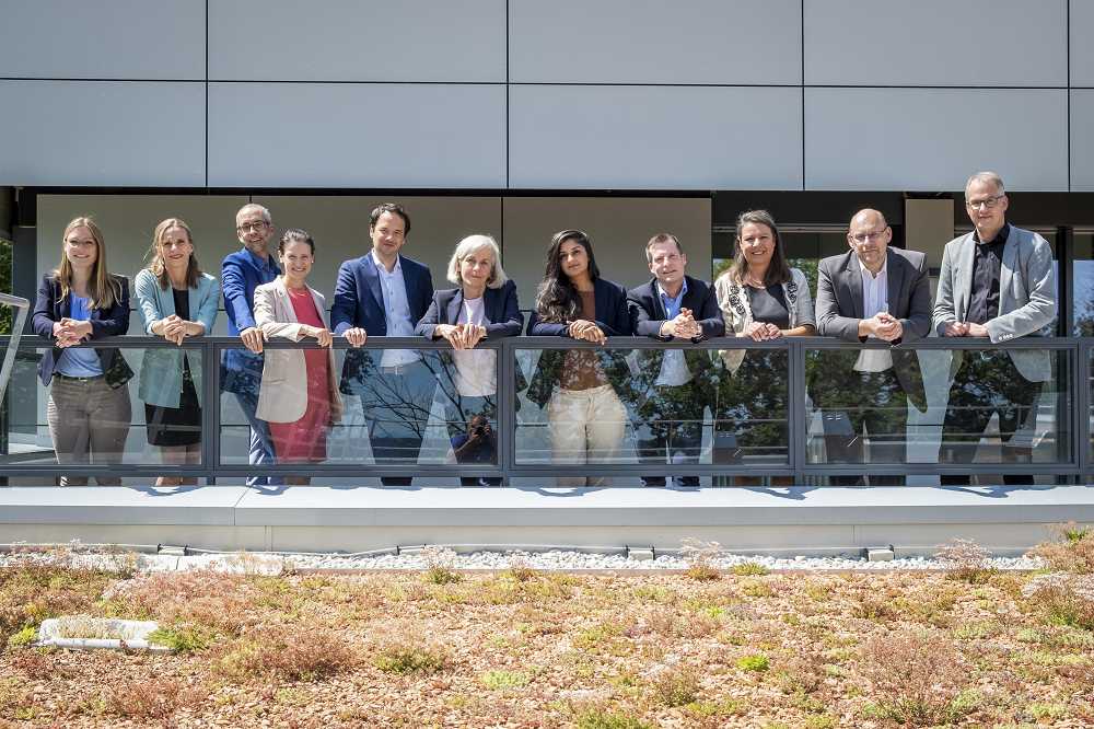 Das Kollegium der Akademie für Politische Bildung steht auf der Terrasse des Gästehauses in einer Reihe und lehnt am Geländer.