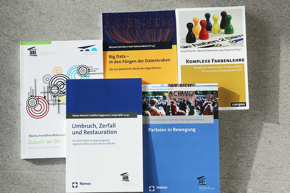 Fünf verschiedene aktuellen Publikationen der Akademie für Politische Bildung liegen nebeneinander und übereinander.