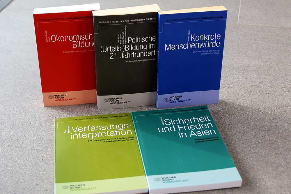 Drei Tutzinger Schriften zur politischen Bildung stehen nebeneinander, zwei liegen davor.